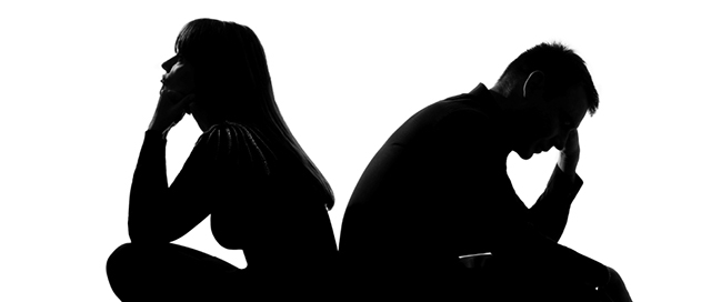 one sad caucasian couple man and woman crouching back to back in studio silhouette isolated on white background