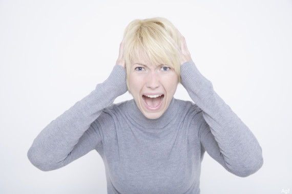 Portrait of young woman shouting against white background, close up